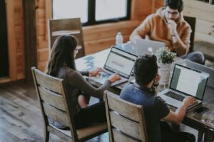 live chat team - selective focus photography of woman and man using MacBook Pro on table